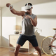 A photo of a man in his white apartment playing in VR using the Quest 2.